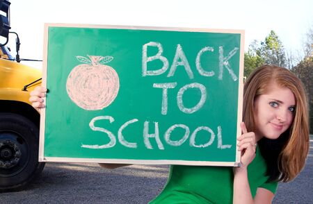 A beautiful teenaged girl holding a back to school sign