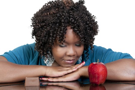 A woman trying to decide whether or not to eat healthyの写真素材