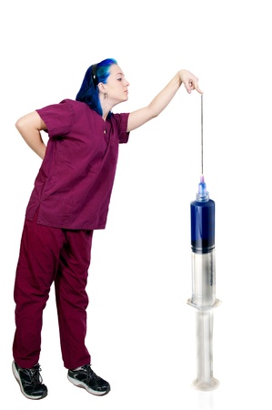 A medical doctor or nurse in scrubs preparing an injection in a giant syringeの写真素材