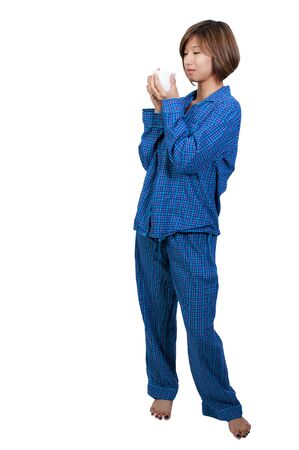 A beautiful young Asian ethnic woman drinking coffee in her pajamasの写真素材