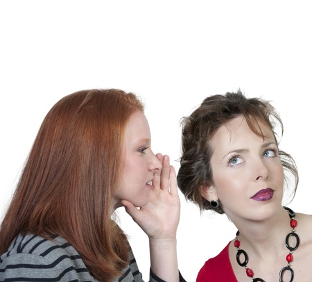 A young beautiful woman whispering a secret to someone else