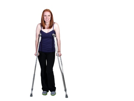 A beautiful woman using a set of medical crutches to help her walkの写真素材