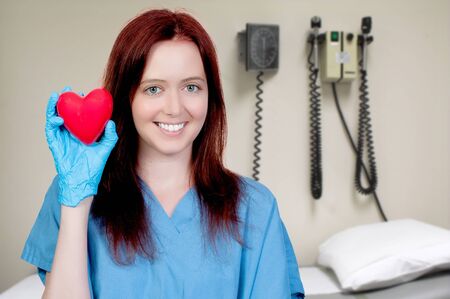 A female cardiologist woman doctor holding a red heart