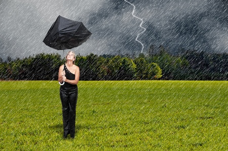 A beautiful young woman holding an umbrella in the rain