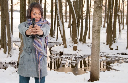 A beautiful black African American police detective woman on the job with a gunの写真素材