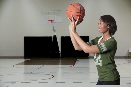 Beautiful black African American woman playing a game of basketballの写真素材