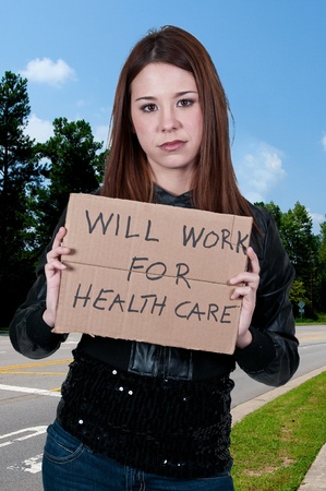 A beautiful woman holding a sign that says will work for healthcareの写真素材