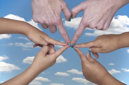 Woman and children forming heart shapes with their hands