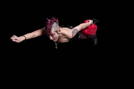 Beautiful punk rock woman flying with a gas canの写真素材