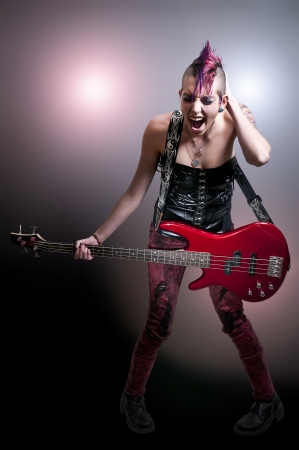 Beautiful woman punk rocker with an electric bass guitar
