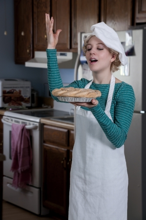 Beautiful woman chef holding a freshly baked pieの写真素材