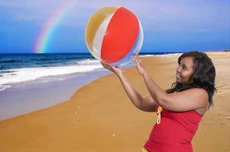 Beautiful sexy young woman at the beach with a rainbowの写真素材