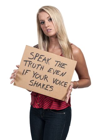 Beautiful young woman holding up an inspirational signの写真素材