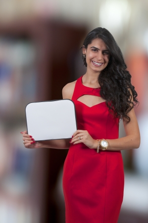 Beautiful young woman holding up a blank signの写真素材