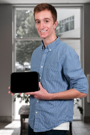 Young man holding up a blank signの写真素材