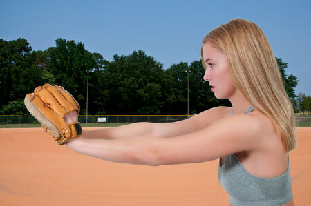 Beautiful woman catchinging a baseball at a ball field