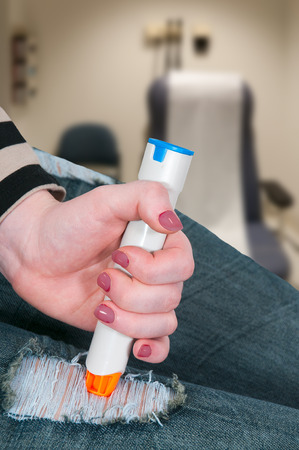 Woman injecting emergency medicine into her legの写真素材