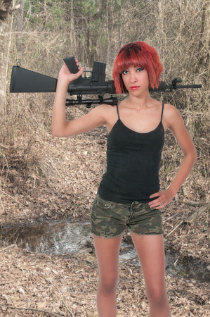 Beautiful young woman soldier with a rifleの写真素材