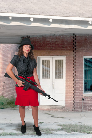 Beautiful young woman holding an automatic assault rifleの写真素材