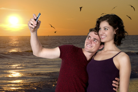 Couple taking a selfie with a cell phoneの写真素材