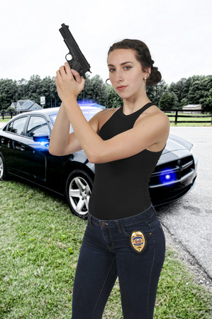 Beautiful police detective woman on the job with a gunの写真素材