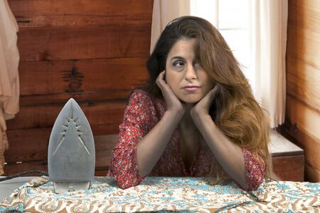 Beautiful woman holding a vintage electric ironの写真素材
