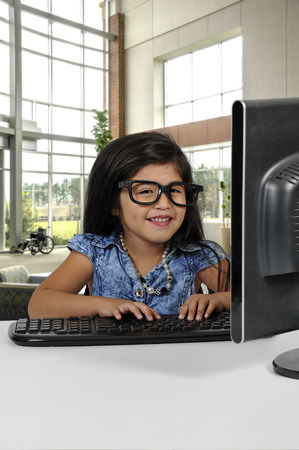 Computer savvy little girl using a desktop computer