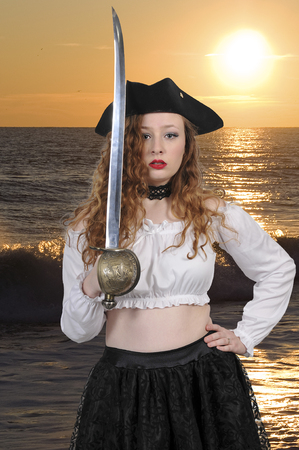 Young beautiful pirate woman with cutlass saber swordの写真素材