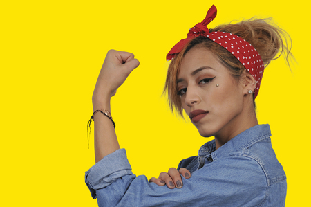 Beautiful woman dressed as the iconic Rosie the Riveter