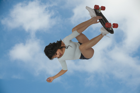 Young woman shreading on a skateboardの写真素材