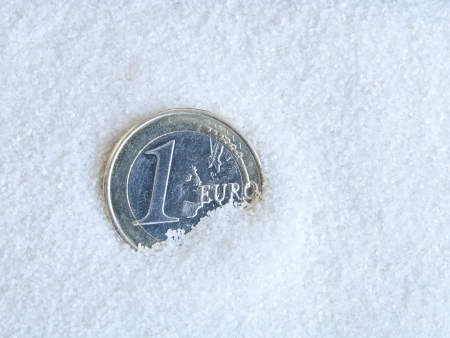 euro coin half buried in sandの写真素材