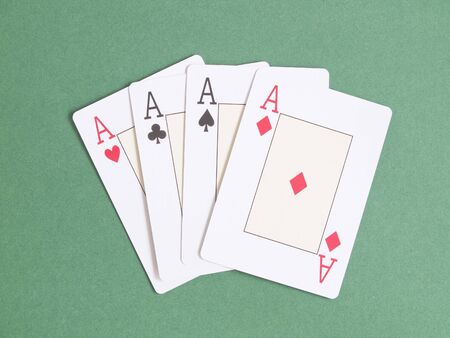 Poker playing cards; four aces over green table