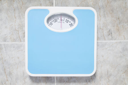 Bathroom scale isolated on bathroom floorの写真素材