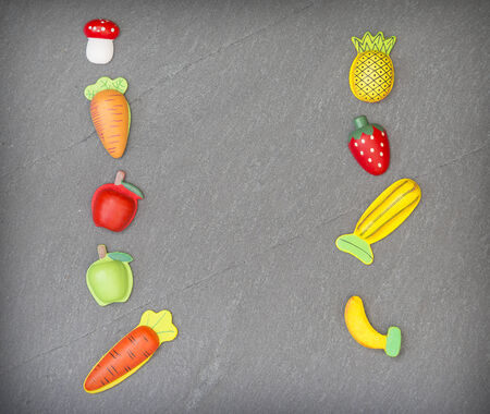 recreation of pieces of fruit and vegetables in slate backgroundの写真素材