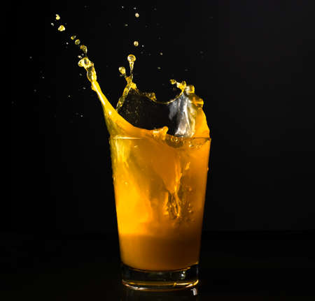 orange juice splash in glassの写真素材