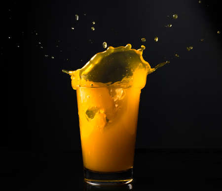 orange juice splash in glassの写真素材