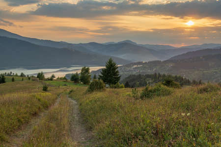 Landscape with a path leading to the village and the lake. The footpath to the west. Golden hourの写真素材