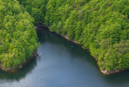 The lake in the forest photographed from above and a green boat. Aerial photographyの写真素材