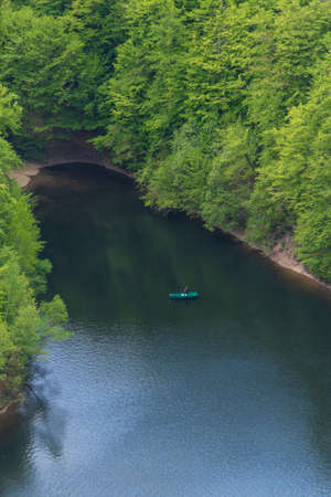 The lake in the forest photographed from above and a green boat. Aerial photographyの写真素材