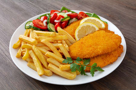 fried chicken fillets, fries and tomatoes with cucumber