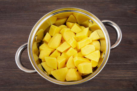 raw potatoes in a potの写真素材