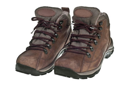 A pair of used hiking boots over a white background.の写真素材
