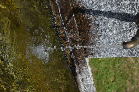 Fresh water is splashing into a fountain in Disentis in Switzerland 8.5.2020