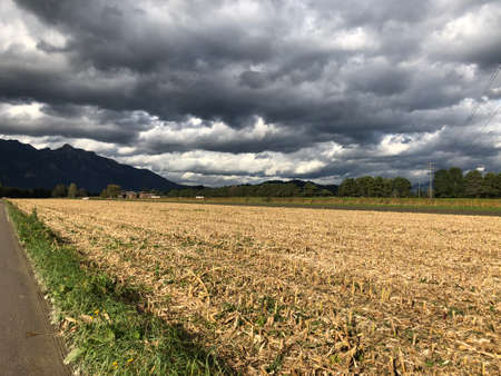 Cumulus clouds in a dramatic formation over farming field in Liechtenstein 10.10.2019の写真素材