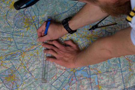 Pilot is calculating his navigation route on an actual map 25.3.2021のeditorial素材