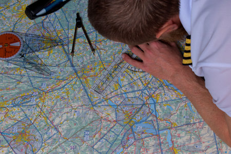 Pilot is calculating his navigation route on an actual map 25.3.2021のeditorial素材