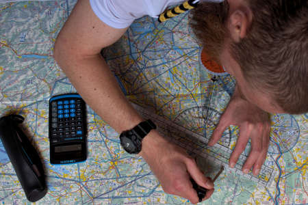 Pilot is calculating his navigation route on an actual map 25.3.2021のeditorial素材