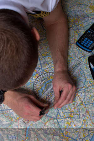 Pilot is calculating his navigation route on an actual map 25.3.2021のeditorial素材
