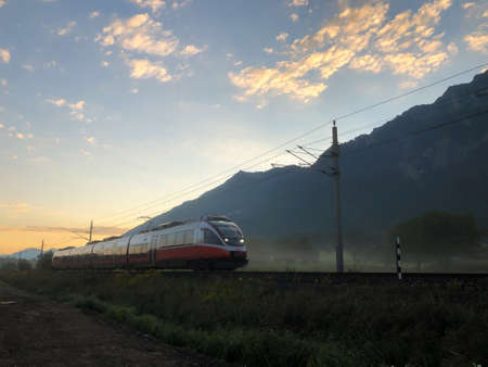 SCHAAN, LIECHTENSTEIN, SEPTEMBER 3, 2021 Morning scenery with an Oebb train and the alps in the backgroundのeditorial素材
