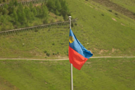 Sareis, Liechtenstein, June 20, 2021 Waving national flag on a mast in the alps